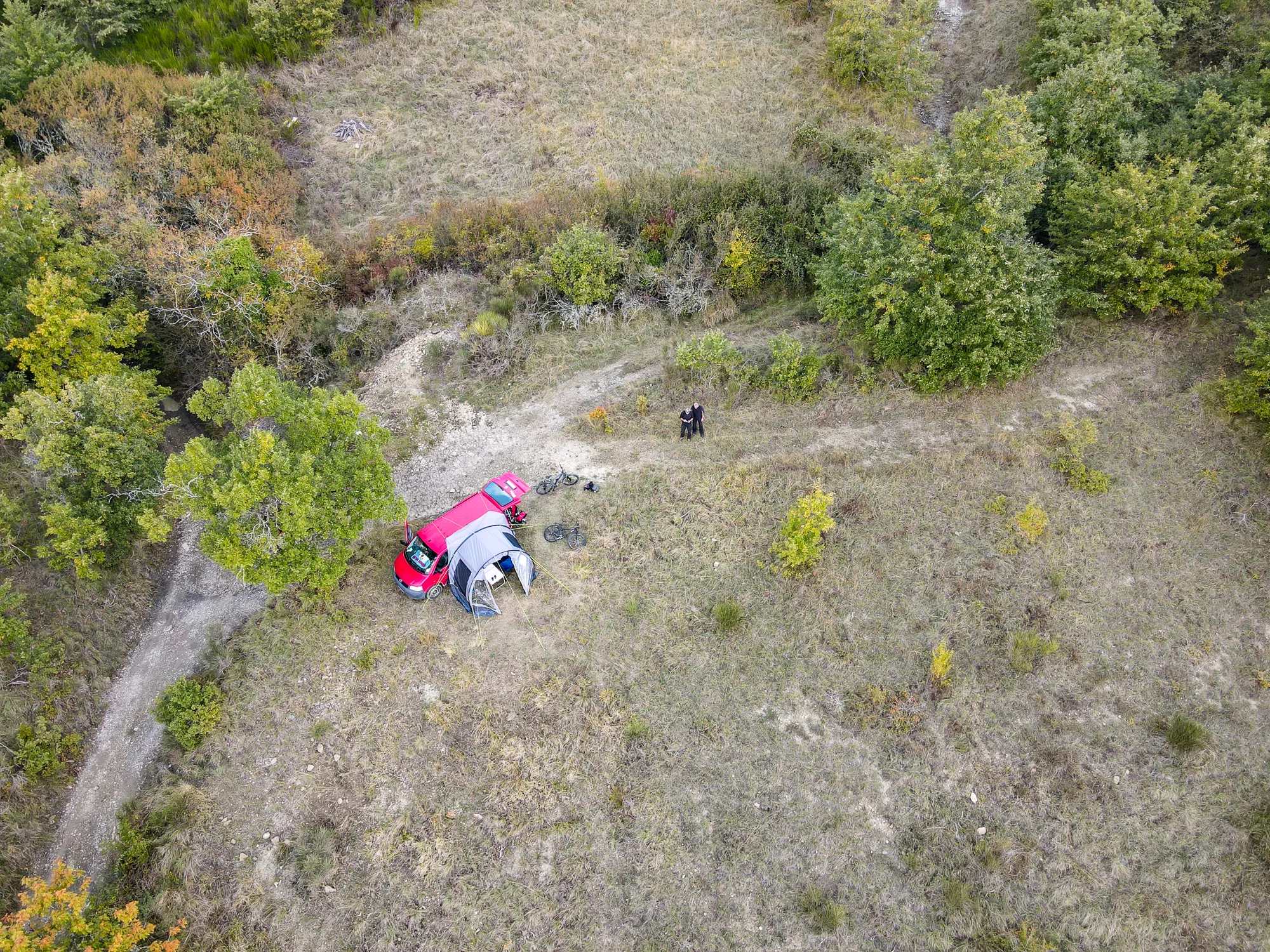 Zelt und roter Wagen im Camp unter Bäumen