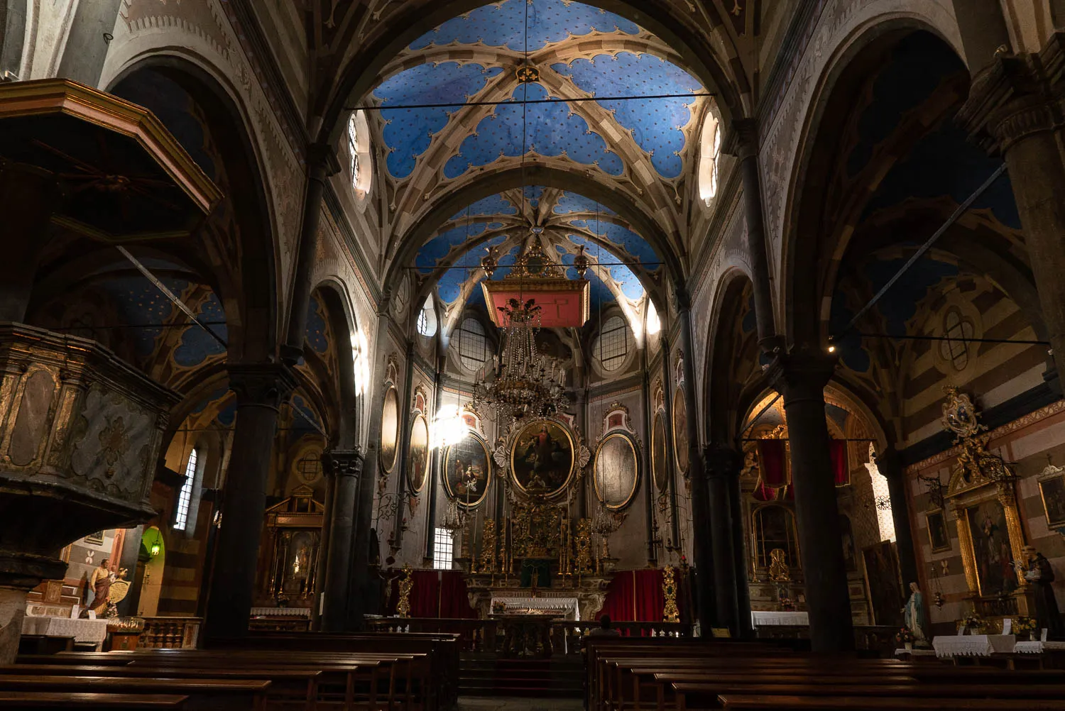 Innenraum einer gotischen Kirche mit bemaltem Gewölbe und Altar