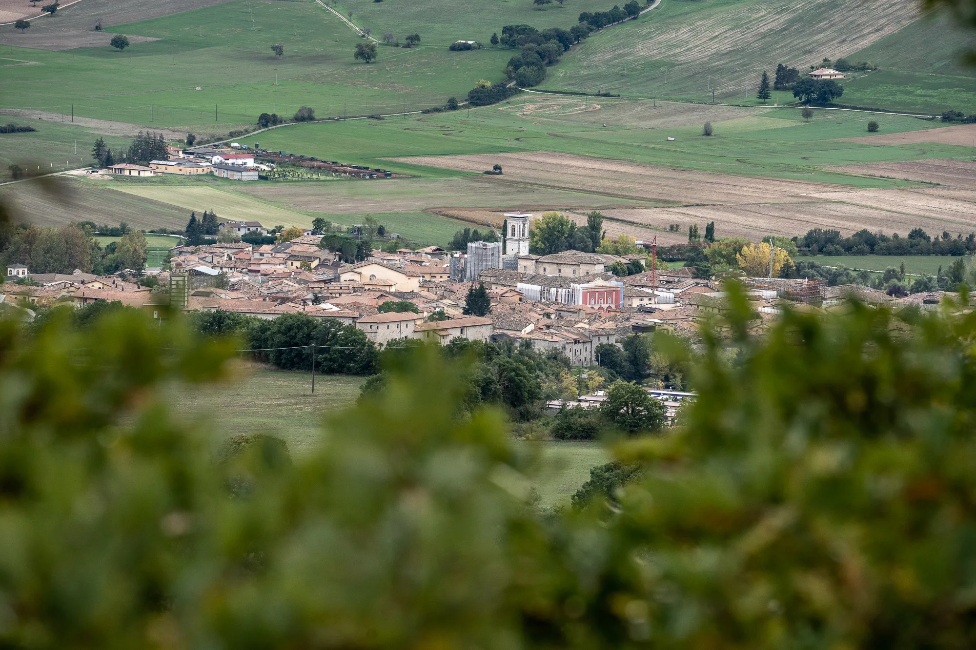 Dorf in den Hügeln von Umbrien mit Kirche und Feldern