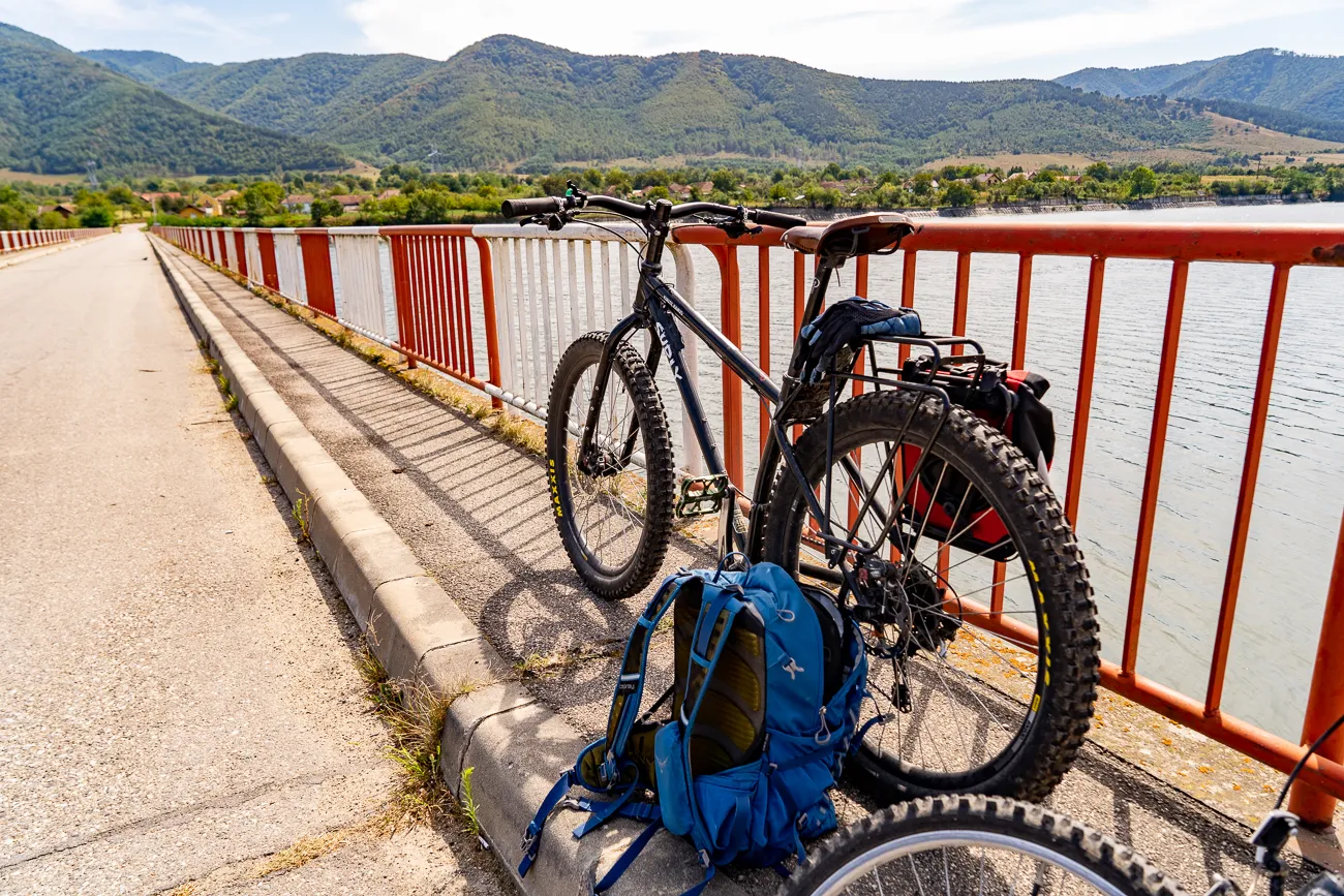 Fahrrad mit Rucksack an Brüstung, Blick auf See und Berge