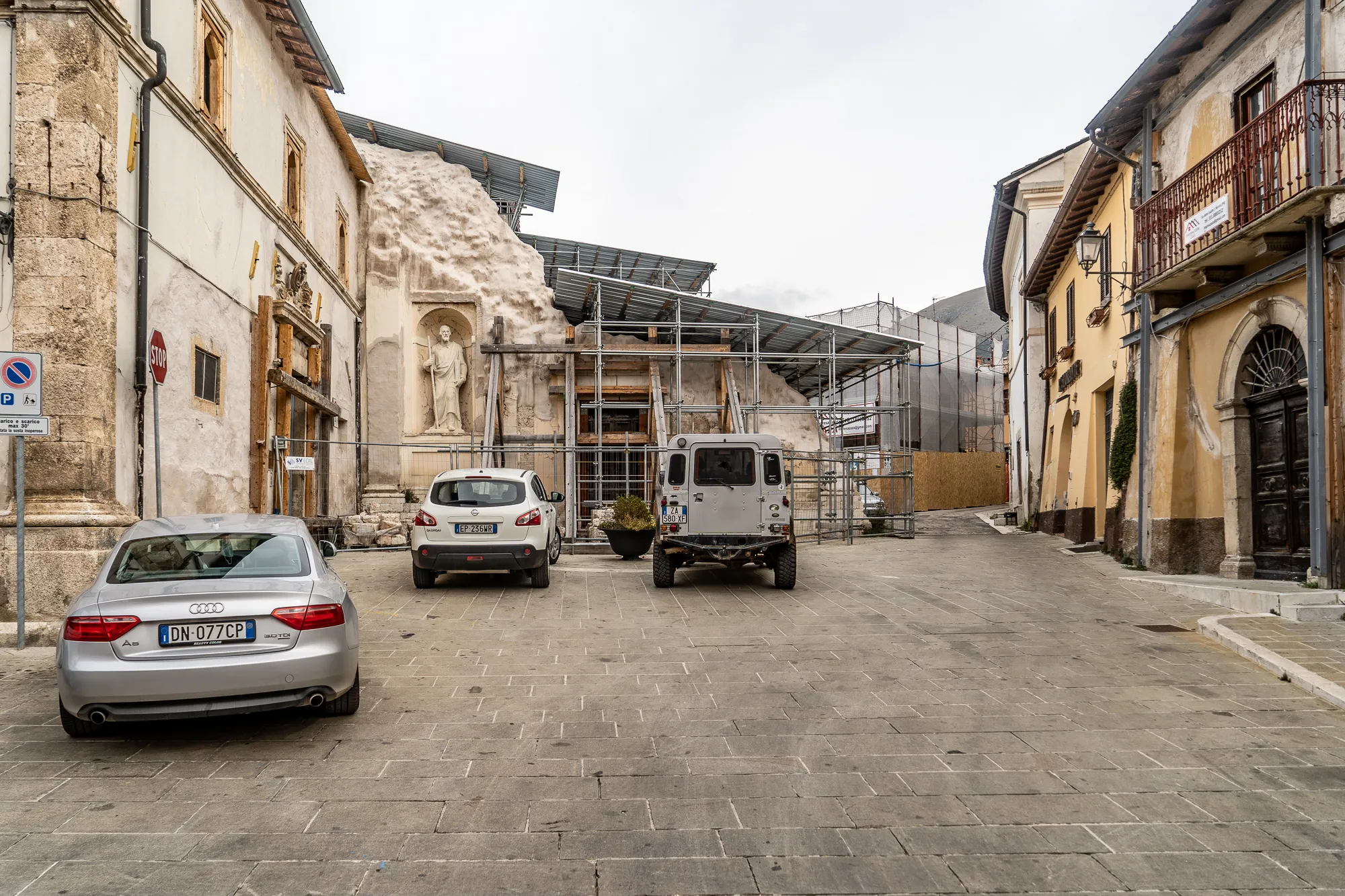 Gasse mit alten Häusern, Bauarbeiten und geparkten Autos