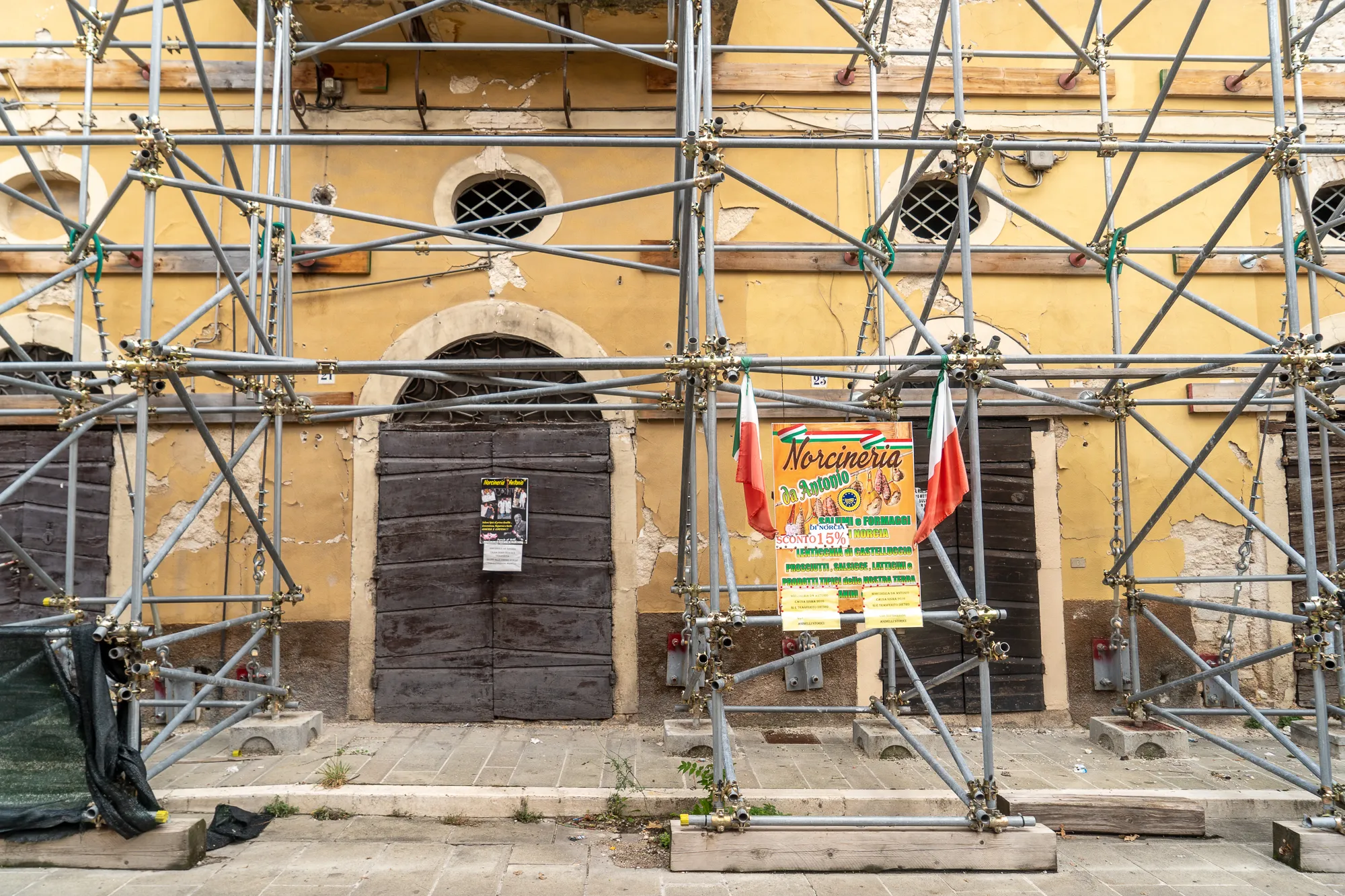 Gelbes Haus mit Scaffolding und italienischer Flagge