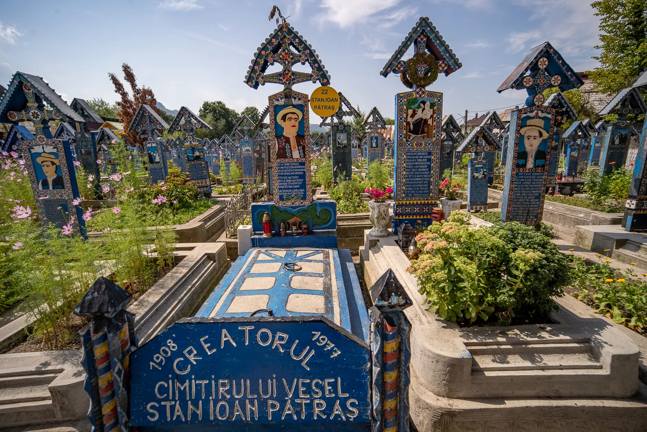 Farbige Grabsteine mit Porträts und Blumen in einem Friedhof