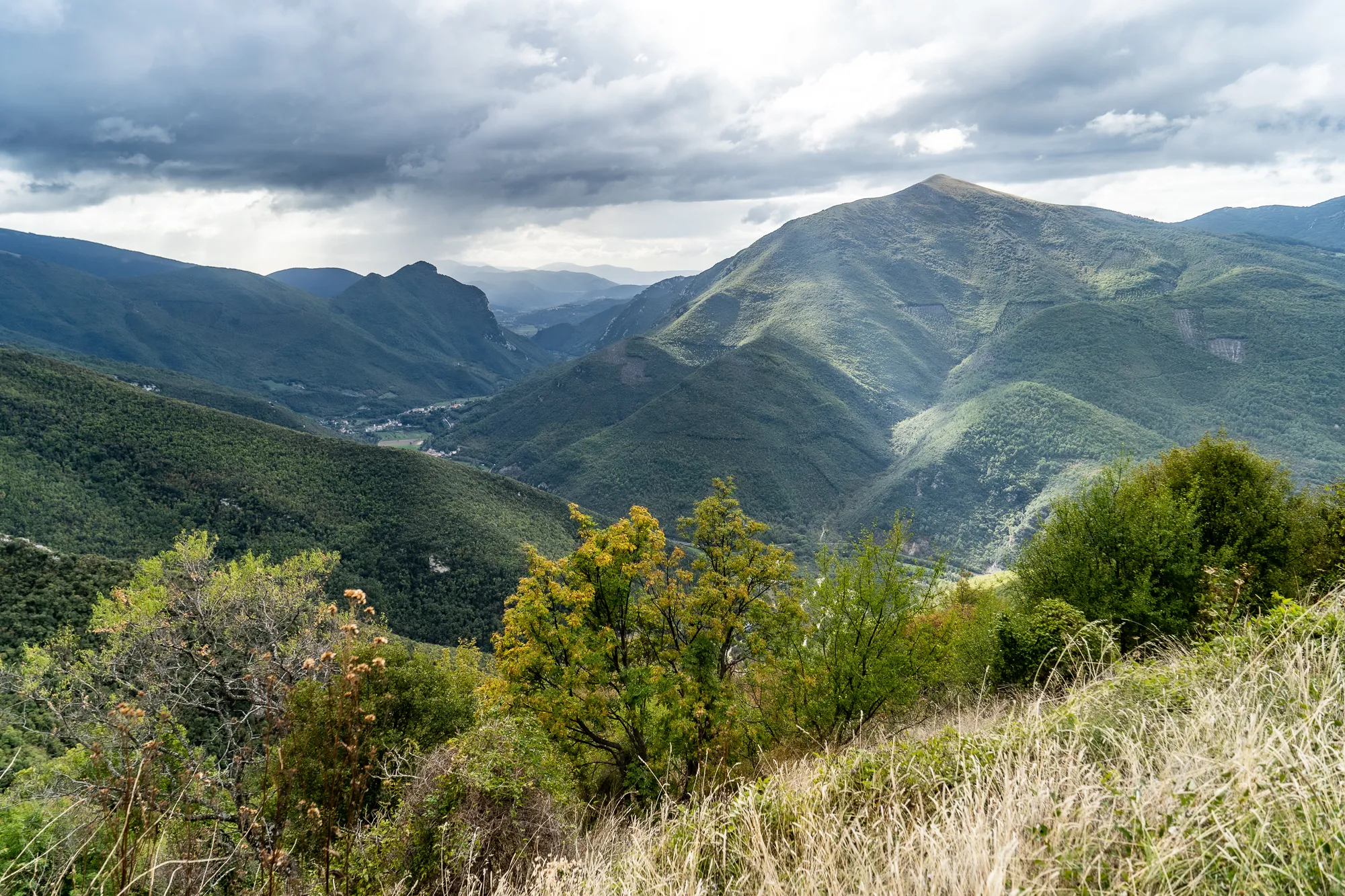 grüne berglandschaft in umbrien unter bewölktem himmel