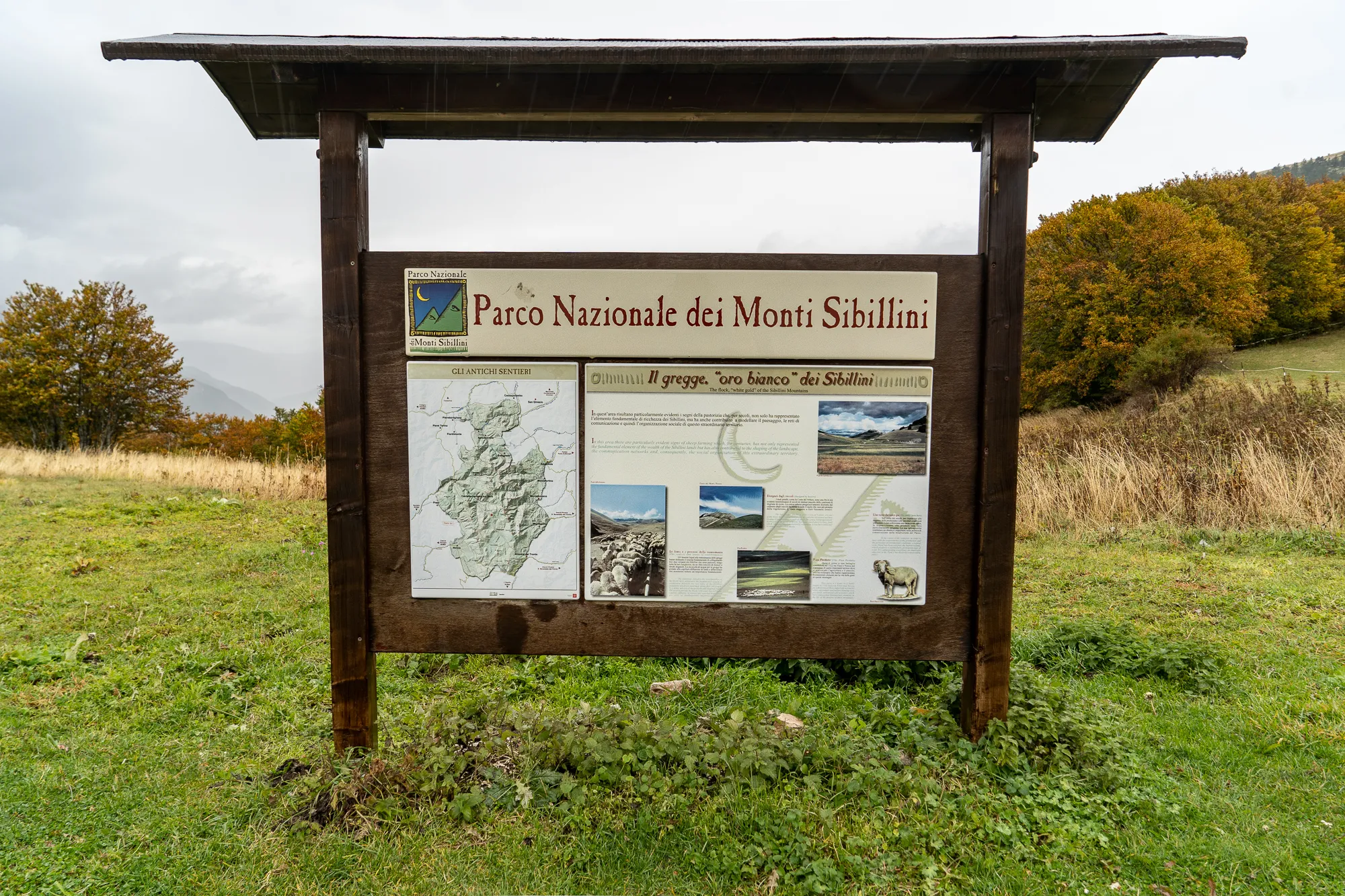 Holzinfo-Schild im Parco Nazionale dei Monti Sibillini mit Karte und Fotos