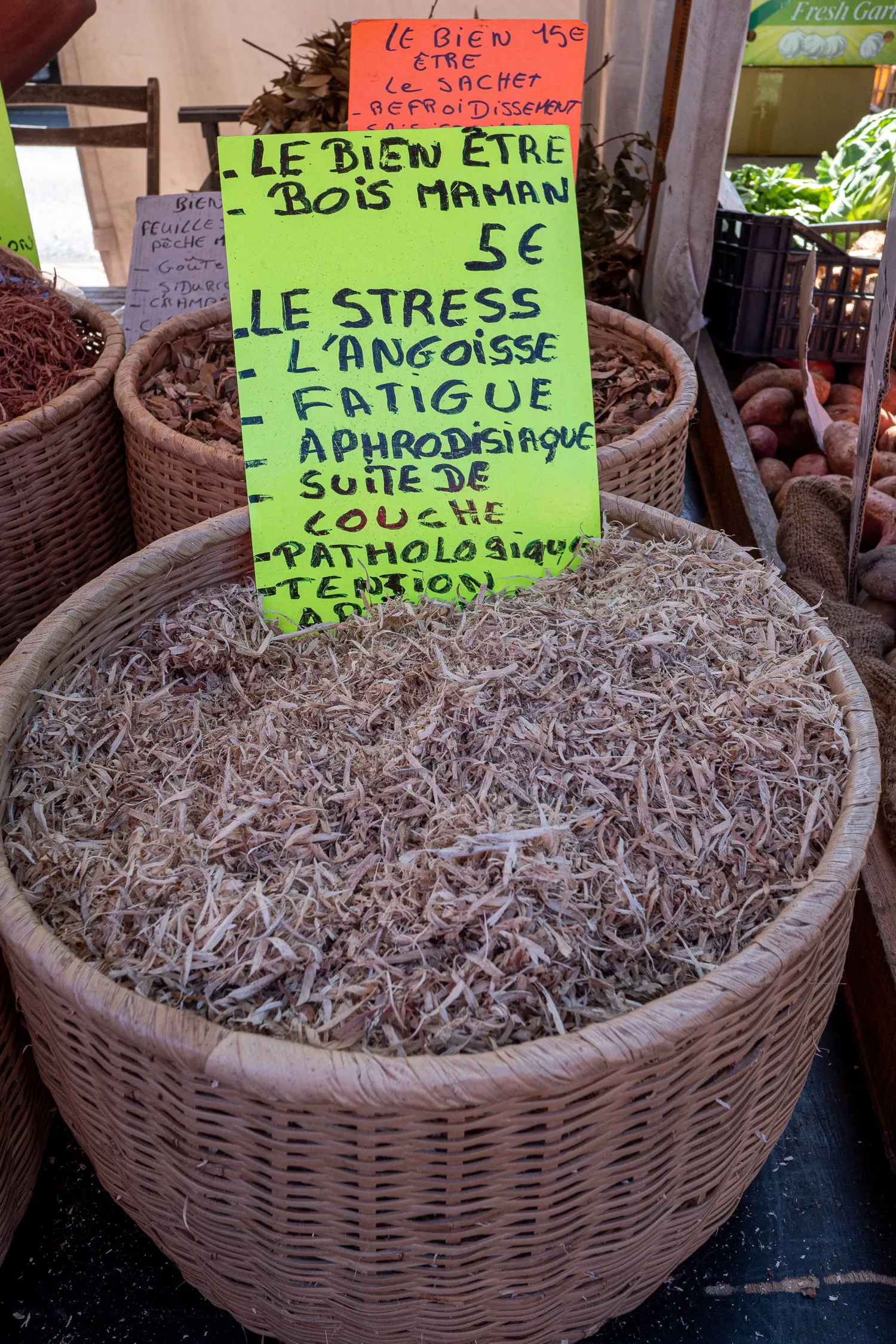Korb mit getrocknetem Kraut und Schild mit Preisen und Beschreibung