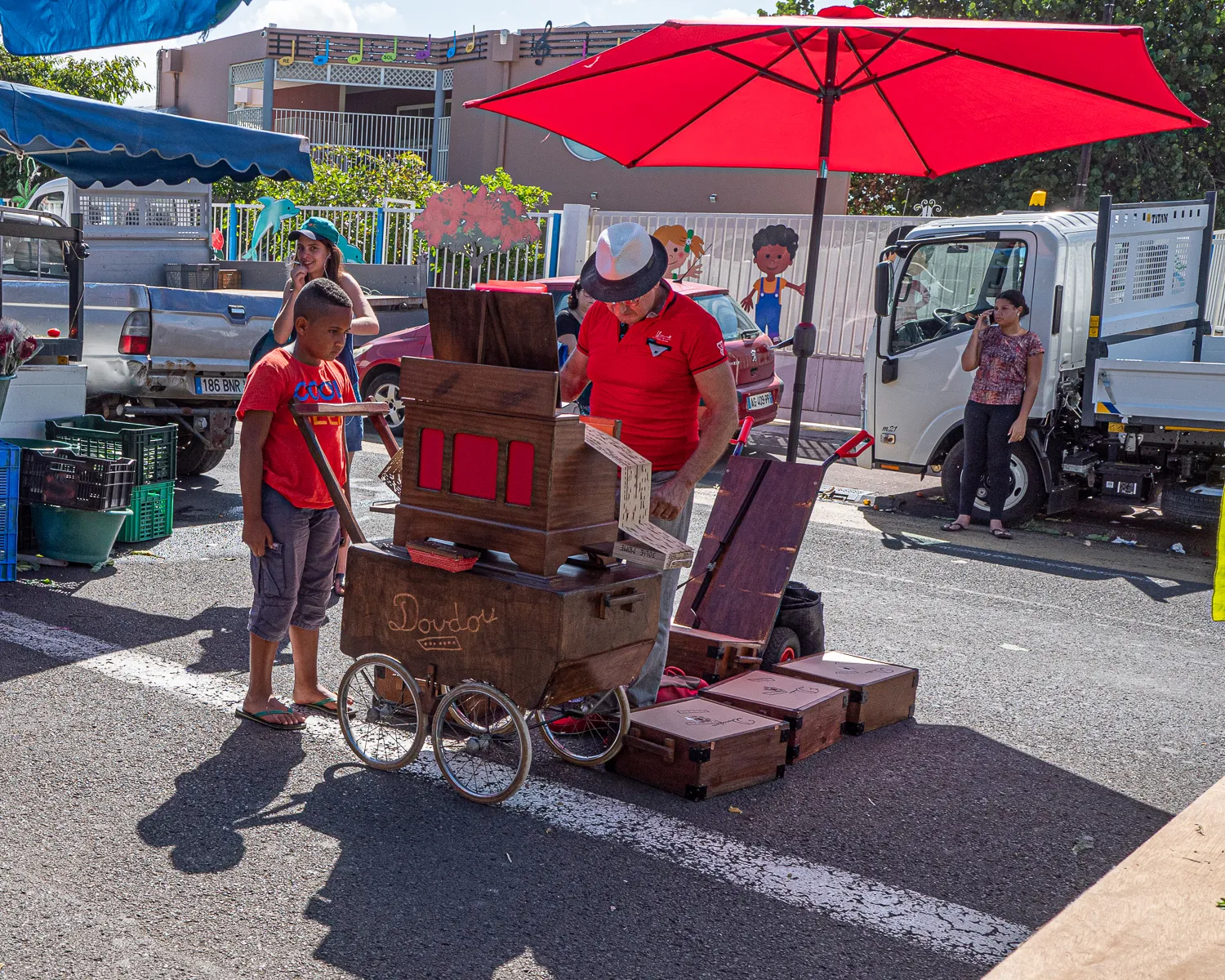 Mann und Junge mit Holzwagen auf Markt in Saint-Pierre