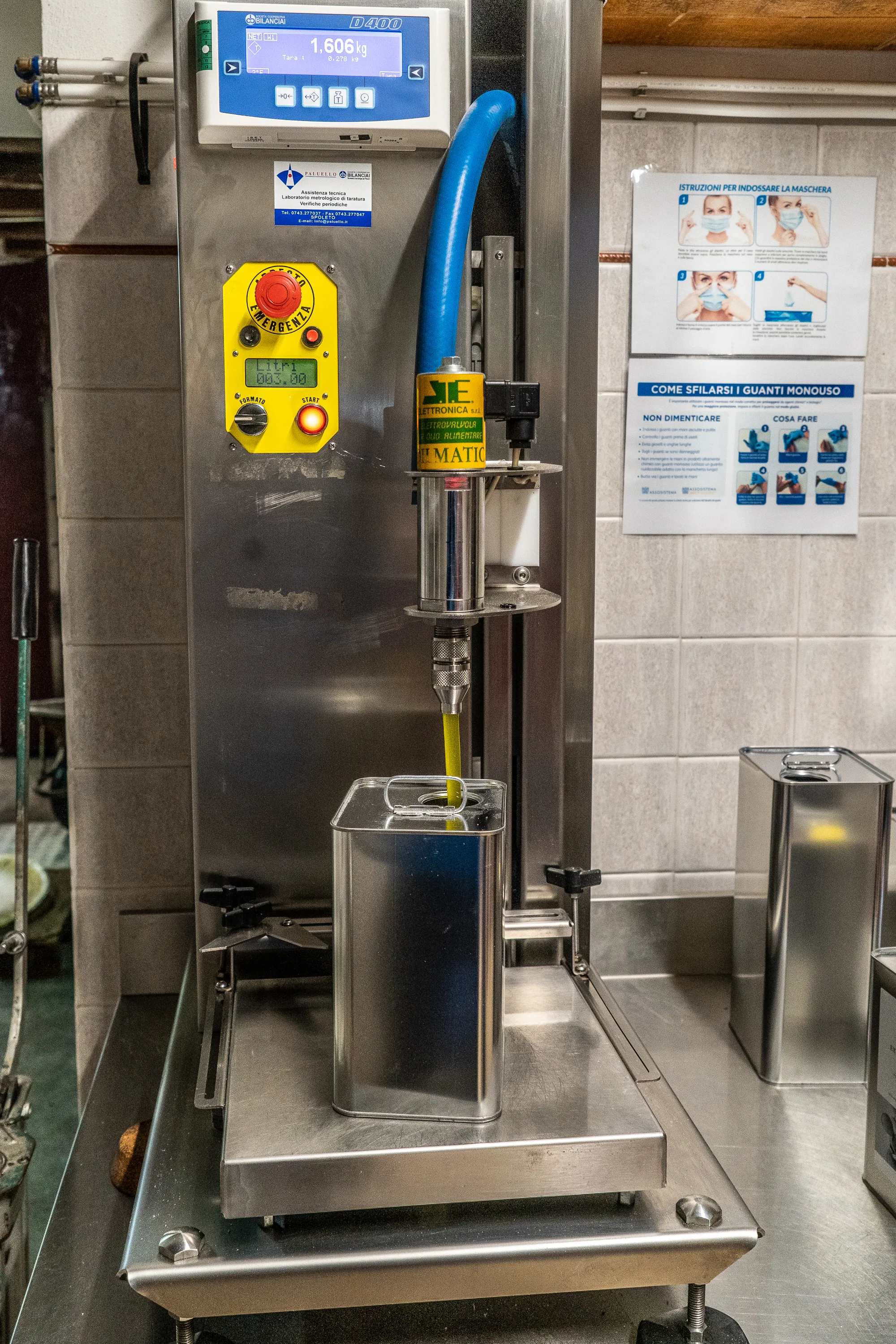 Automatische Maschine füllt einen Metallkanister mit gelbem Flüssigkeitsinhalt.