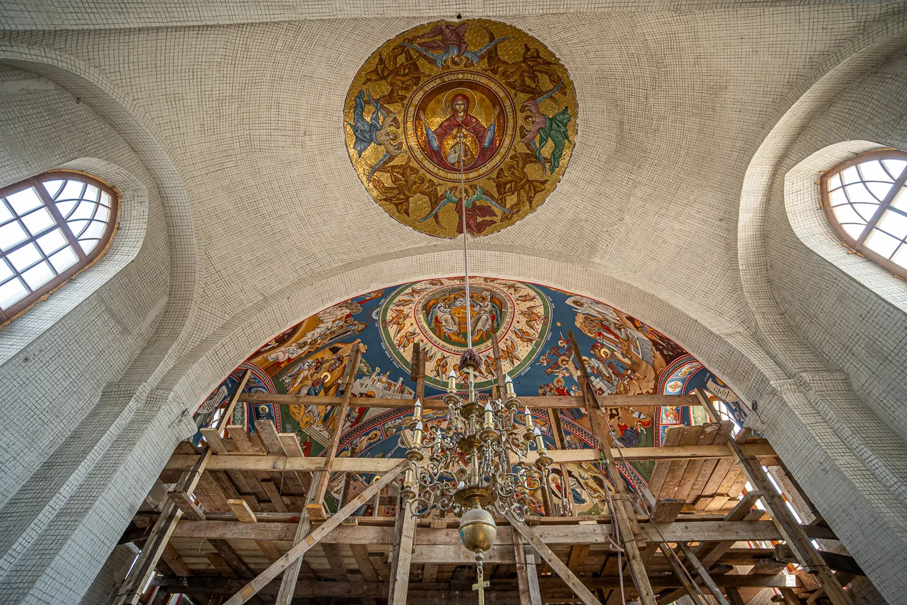 Innenraum einer Kirche mit Mosaikgewölbe und Holzgerüst