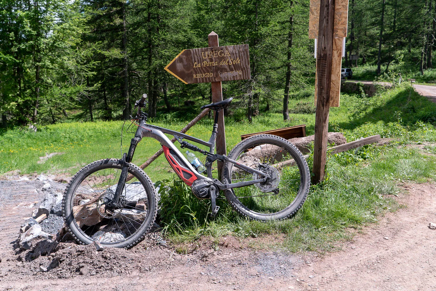 Mountainbike lehnt an Holzschild im Wald