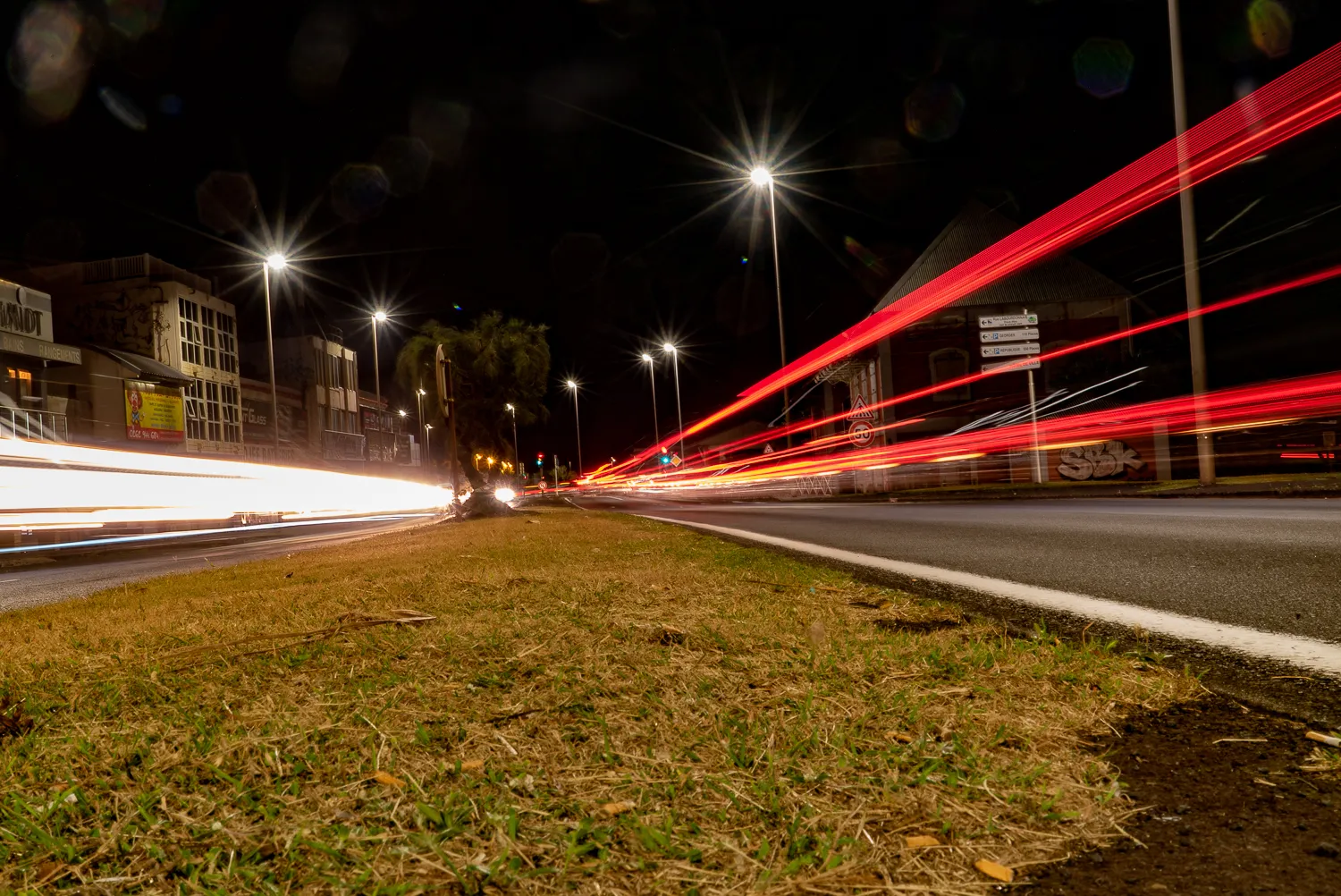 Nachtansicht einer Straße mit Lichtspuren von Fahrzeugen und Straßenlaternen