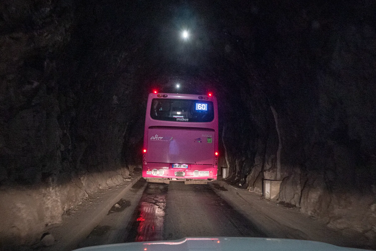 Pink Reisebus im Tunnel mit Rücklichtern und Schild 60
