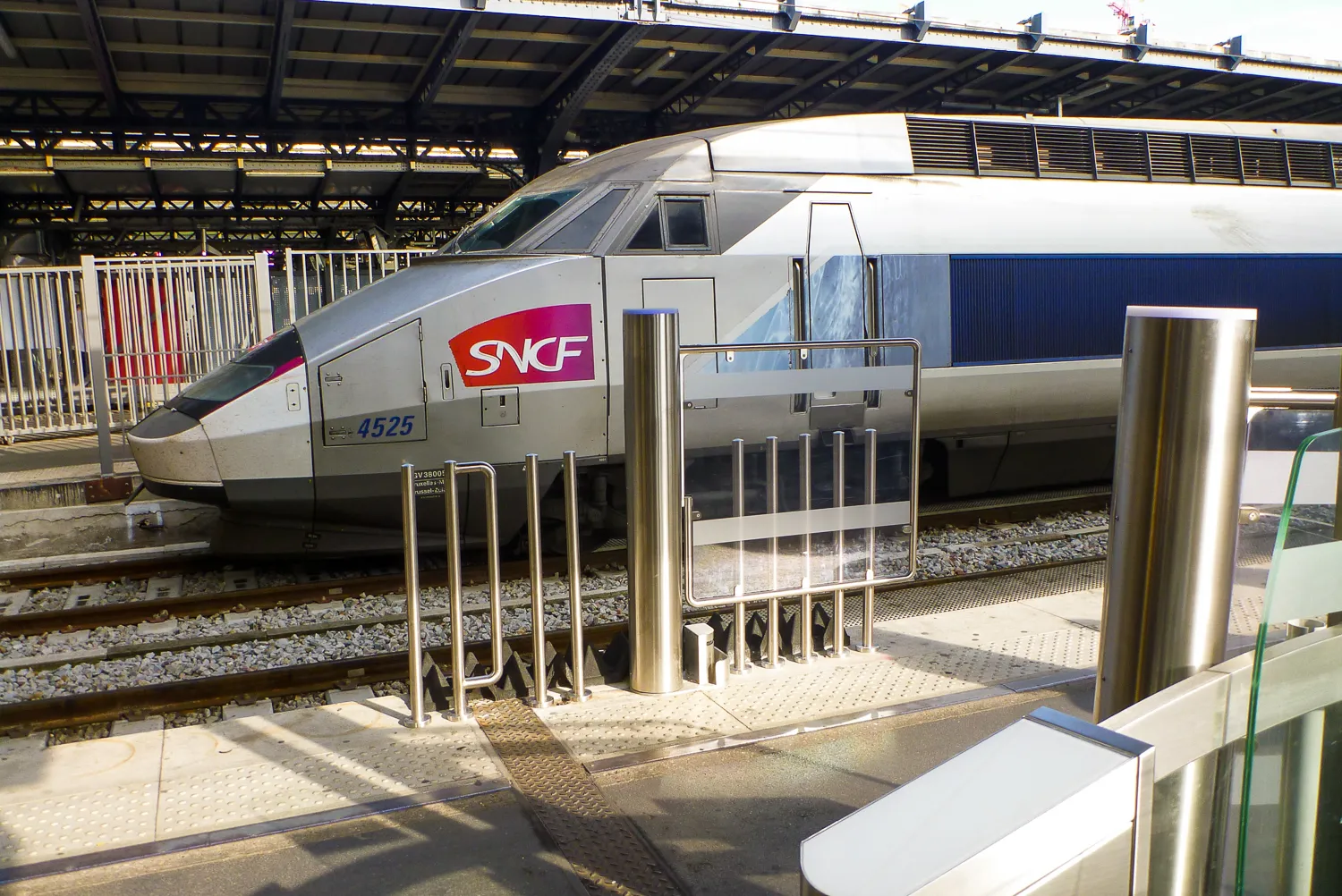 Silberner Hochgeschwindigkeitszug mit SNCF-Logo an Bahnhofsgleis