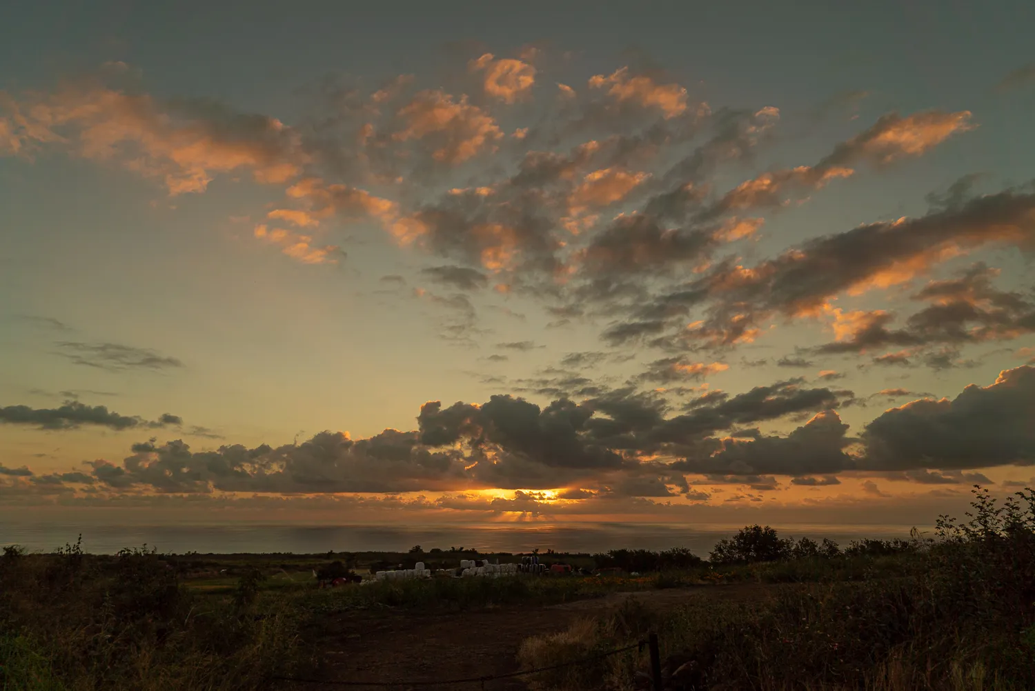 Sonnenuntergang mit orangefarbenen Wolken über flachem Landschaftshorizont