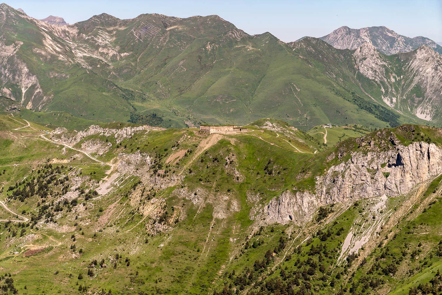 grüne berglandschaft mit steilen hängen und felsformationen