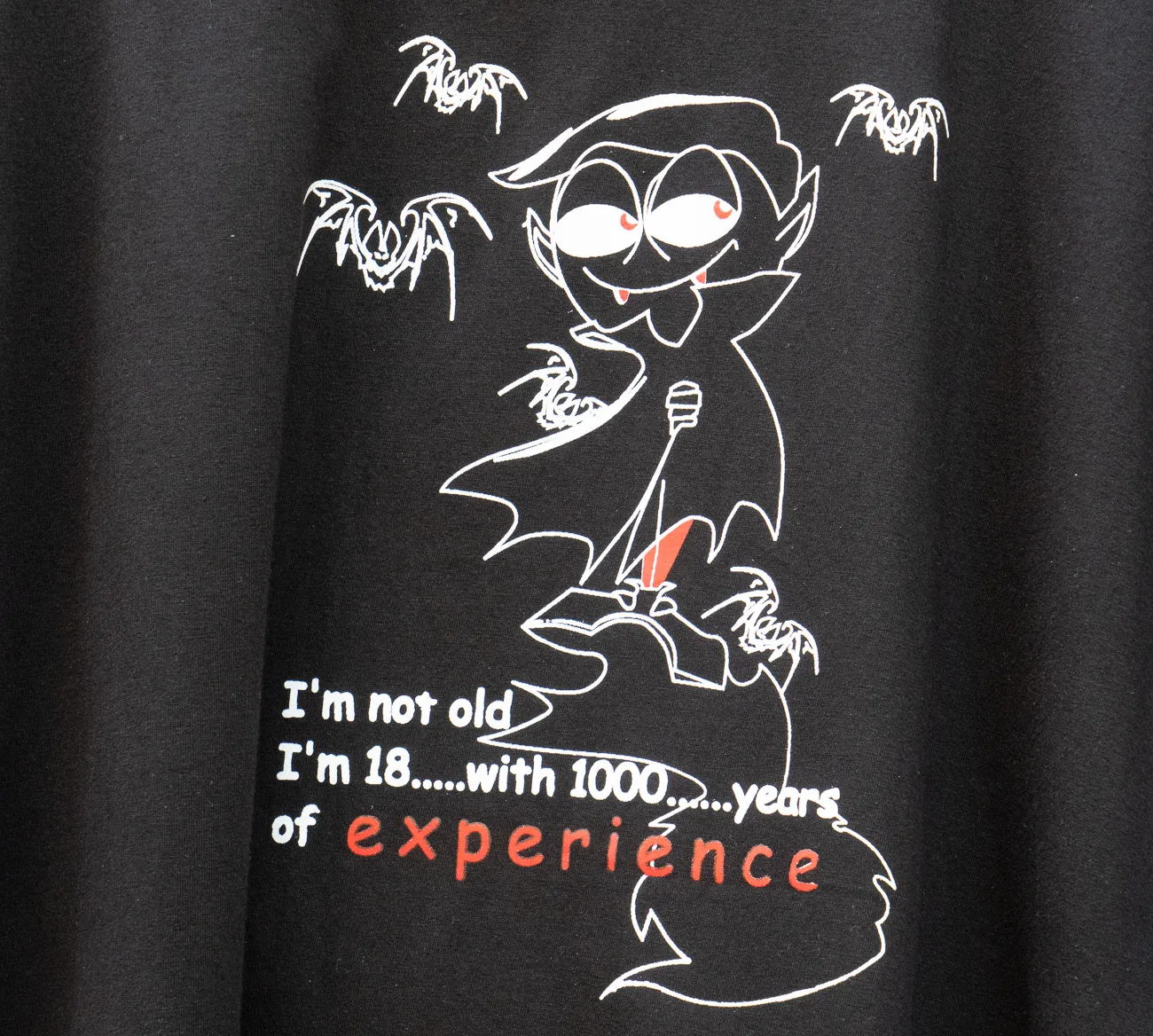 Schwarzes T-Shirt mit Cartoon-Vampir und Text über Erfahrung