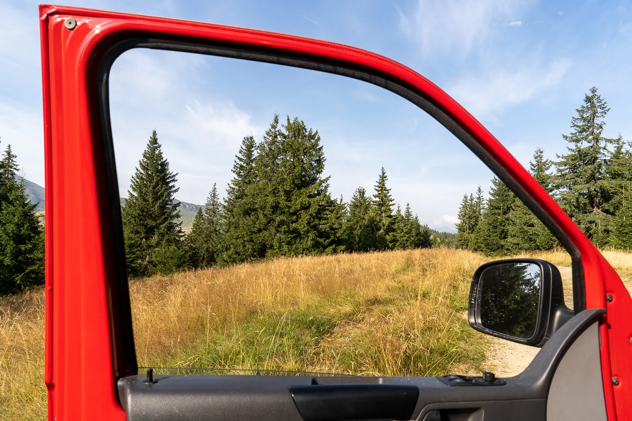 roter wagen mit offenem fenster im bergland