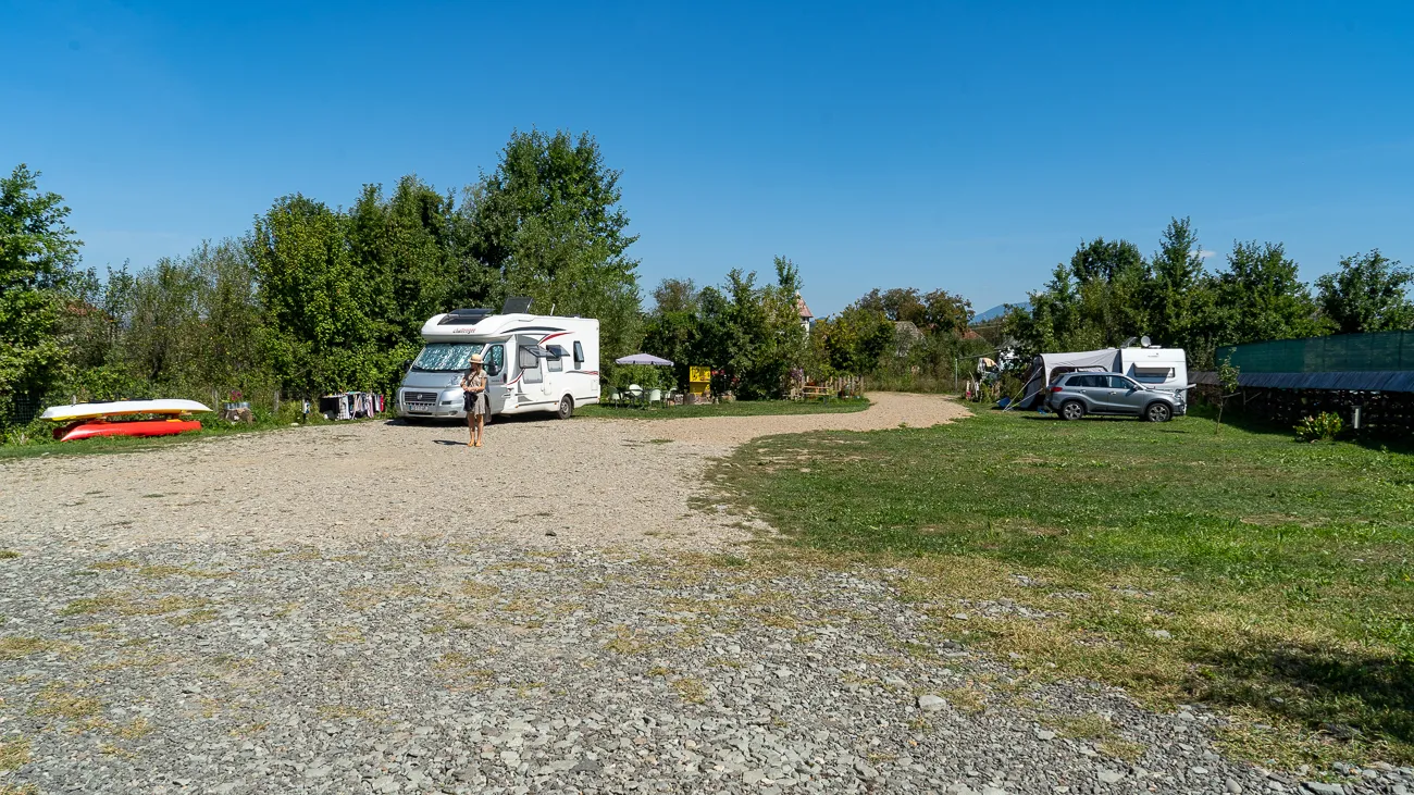 Campingplatz mit Wohnmobil, Gras und Bäumen unter blauem Himmel